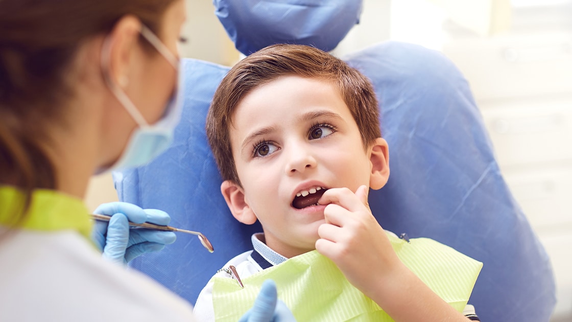 Worried child wiggling his tooth