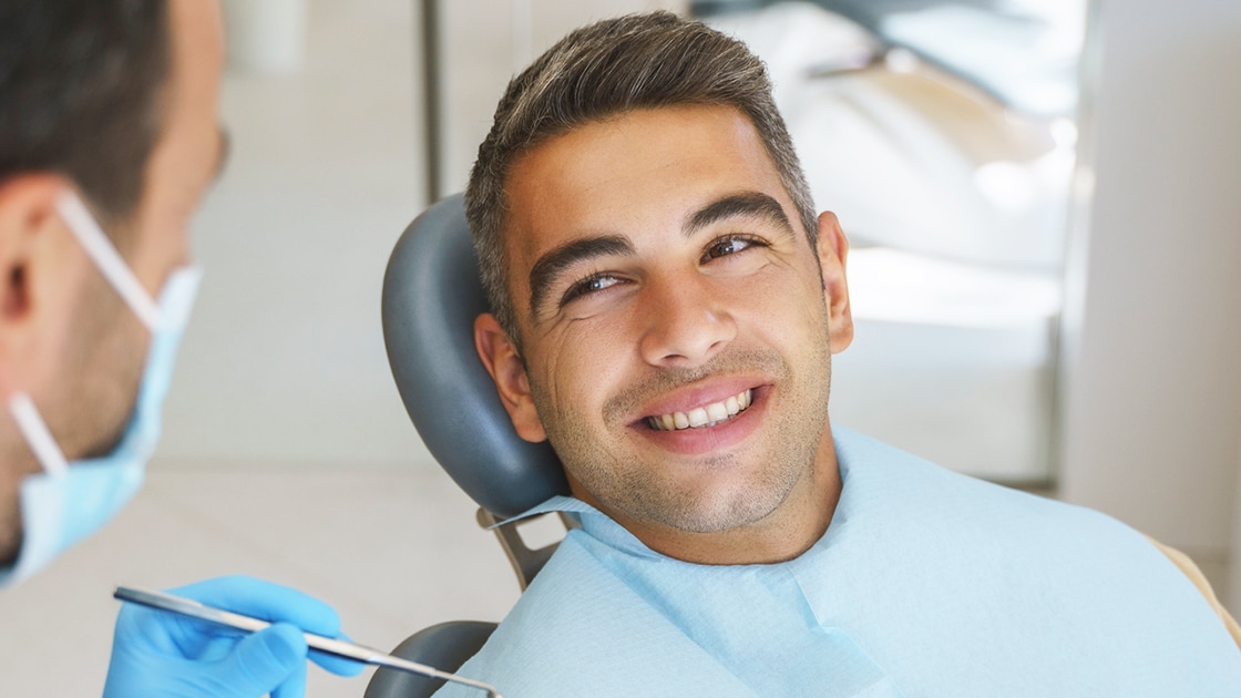 Handsome man talking with dentist