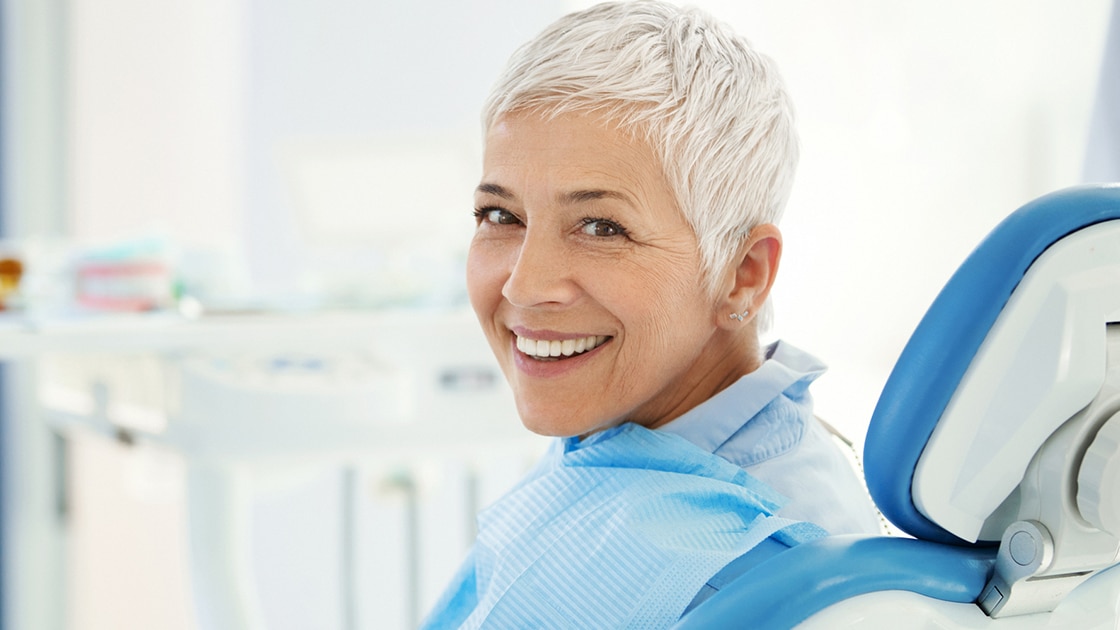 Woman with white hair in dental chair